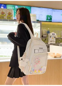 Vista detallada de mochila lisa con bolsillo transparente y decoración de peluche lindo.