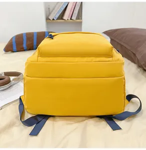 Close-up of the bright yellow backpack detail, featuring durable blue straps and zippers.