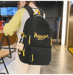 Minimalist black backpack with yellow letter print and cute pendant, casual daily use style.