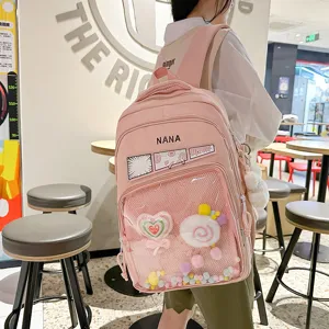 Mochila escolar rosa de estilo japones con bolsillo frontal transparente para uso diario.