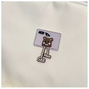 Detailed view of cute cartoon bear rubber badge on casual canvas backpack stylish accessory