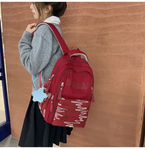 Detail view of large capacity backpack side view, showing strap design and front embroidery.
