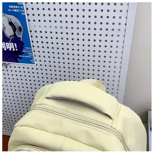 Close-up of a fresh yellow casual backpack with dual zippers and comfortable top handle.
