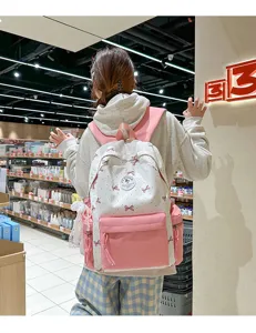Detailed shot of pink nylon school backpack with cute bow pattern and large daily capacity.