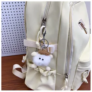 Light yellow casual daily backpack detail view featuring cute plush keychain and smooth zippers.