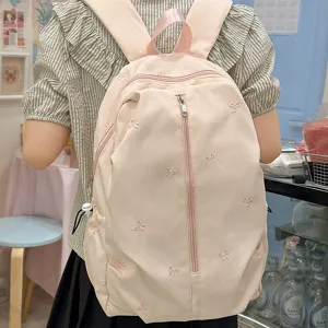 Cute pink canvas backpack with bow embroidery, stylish casual school bag for daily use.