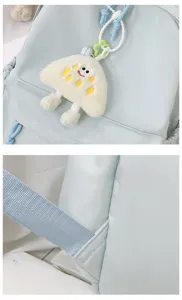Detailed view of the cute plush pendant and reinforced strap craftsmanship on the light blue backpack.