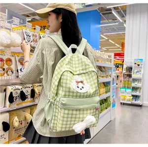 Green plaid backpack detail in store showing cute puppy patch, large capacity and daily style.