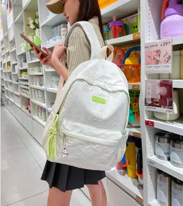 Stylish white textured backpack for women, casual daily school book bag with cute bear pendant.