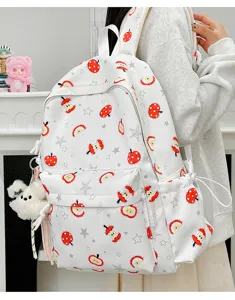 Detail view of cute apple print canvas backpack, featuring front pocket and school style.