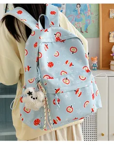 Cute light blue apple print backpack detail view, sweet style school bag with plush pendant.