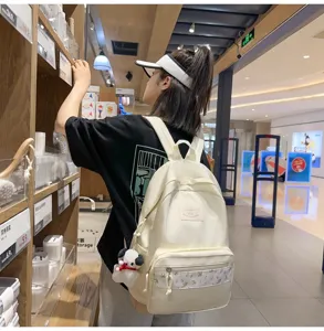 Detailed view of the Korean style casual canvas backpack with floral pocket and cute pendant.