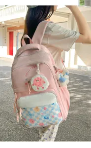 Detailed view of a stylish pink casual school backpack worn outdoors with cute cartoon prints.