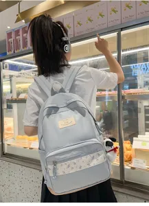 Detailed view of light blue canvas backpack with floral patchwork, daily casual student bag.