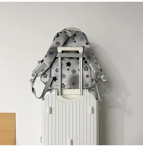 Detail view of the grey star print casual backpack featuring convenient luggage strap for travel use.