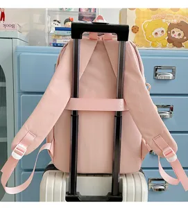 Pink travel school backpack with luggage strap detail, casual daily daypack for students.
