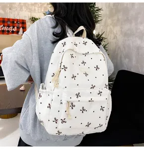 Casual white canvas backpack with cute black bow and dot pattern, large capacity daily use.