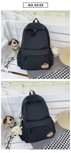 Detailed view of casual black backpack with front pocket and cute patch, minimalist style.