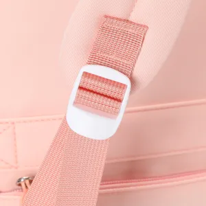 Dettaglio del regolatore della cinghia dello zaino rosa e della fettuccia resistente.
