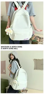 Detailed view of the minimalist white school backpack with cute pendant for casual use.