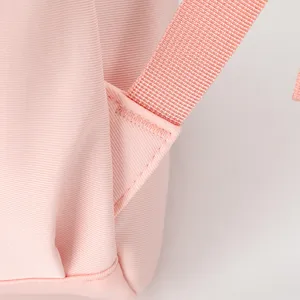 Dettaglio della cinghia dello zaino rosa, tessuto impermeabile resistente all'usura.