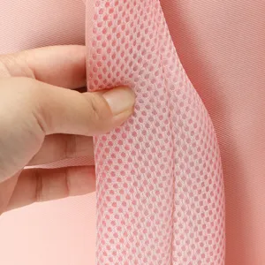 Primo piano del dettaglio della tracolla in rete dello zaino rosa, materiale resistente.