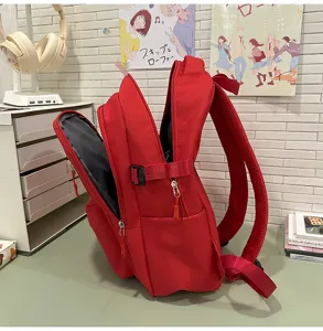 Vue détaillée du sac à dos rouge montrant la poche latérale, la fermeture éclair et la sangle.