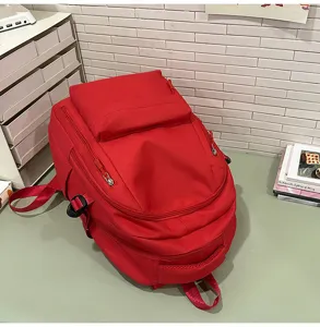 Sac à dos rouge minimaliste de grande capacité pour les déplacements quotidiens et l'école.