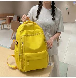Détail de sac à dos scolaire jaune avec poches multiples, style décontracté et grande capacité.