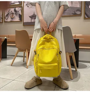 Vue du sac à dos jaune en toile, style décontracté avec grande capacité pour le quotidien.