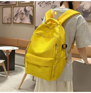 Vue detaillee du sac a dos jaune en toile montrant ses poches pratiques et ses larges bretelles.