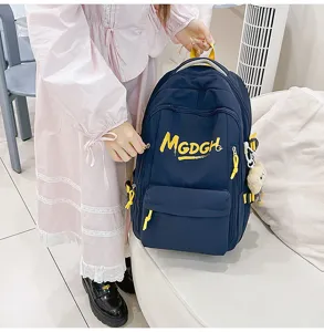 Detail view of casual large capacity backpack with yellow letter print and handy side pendant.