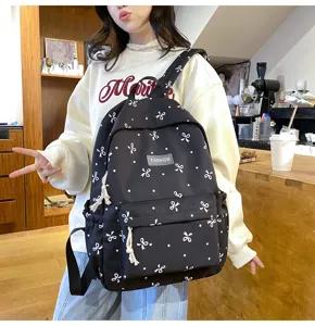 Casual black school backpack with cute white bow and dot print, large capacity daily bag.