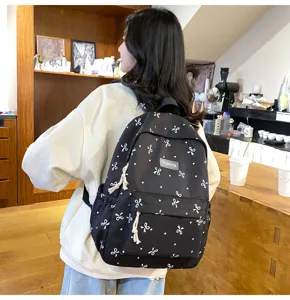 Casual black backpack with cute white bow print, large capacity daily school bag for students.