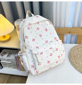 Detailed view of white canvas casual backpack with pink bow and dot patterns, daily use.