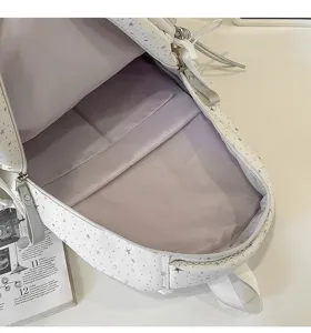Detail view of the white star pattern backpack interior with multiple compartments and soft lining.