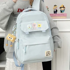Cute light blue casual backpack for students, large capacity school bag with fun charms.