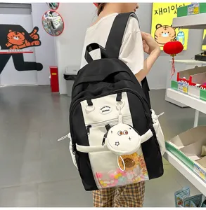 Detailed view of black and white ita backpack, transparent pocket, cute pendant, durable straps.