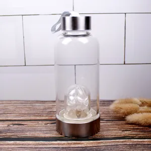 Detail view of crystal glass water bottle with stainless steel cap and gemstone chamber.