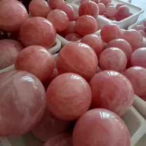 Natural polished rose quartz crystal sphere for interior home decor and feng shui display.