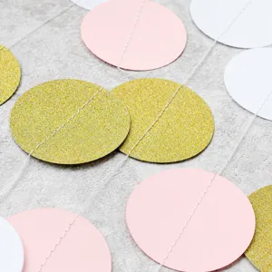 Detail view of colorful round paper garland, gold glitter, pink and white party hanging decor.