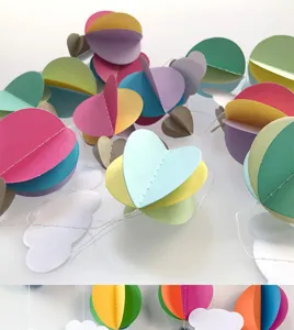 Colorful 3D paper hot air balloon and cloud hanging decoration details for kids party.