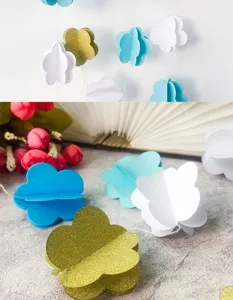 Close-up detail of 3D paper cloud hanging garland for kids birthday party and room decor.