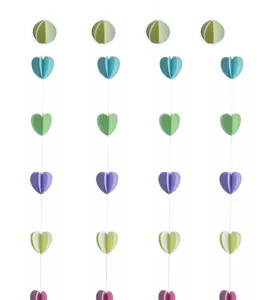 Hanging 3D paper heart and sphere garland decorations for kids birthday party background setup.