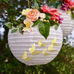 Vue détaillée de la lanterne en papier blanc avec fleurs et stickers papillons 3D dorés.