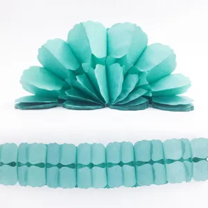 Detailed close-up of light blue tissue paper party decoration garland and flower fan detail shot.