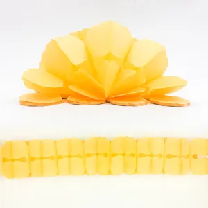 Yellow paper honeycomb flower and clover garland string detail close-up view for party.