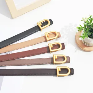 Close-up detail view of women thin leather belts showcasing elegant gold D-shaped buckles.