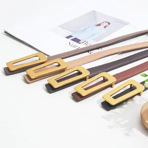 Women stylish leather belt detail, minimalist gold rectangular metal buckle, elegant strap.
