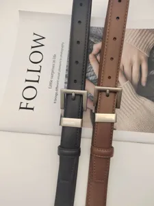 Detailed view of minimalist womens leather belt featuring classic metal buckle and holes